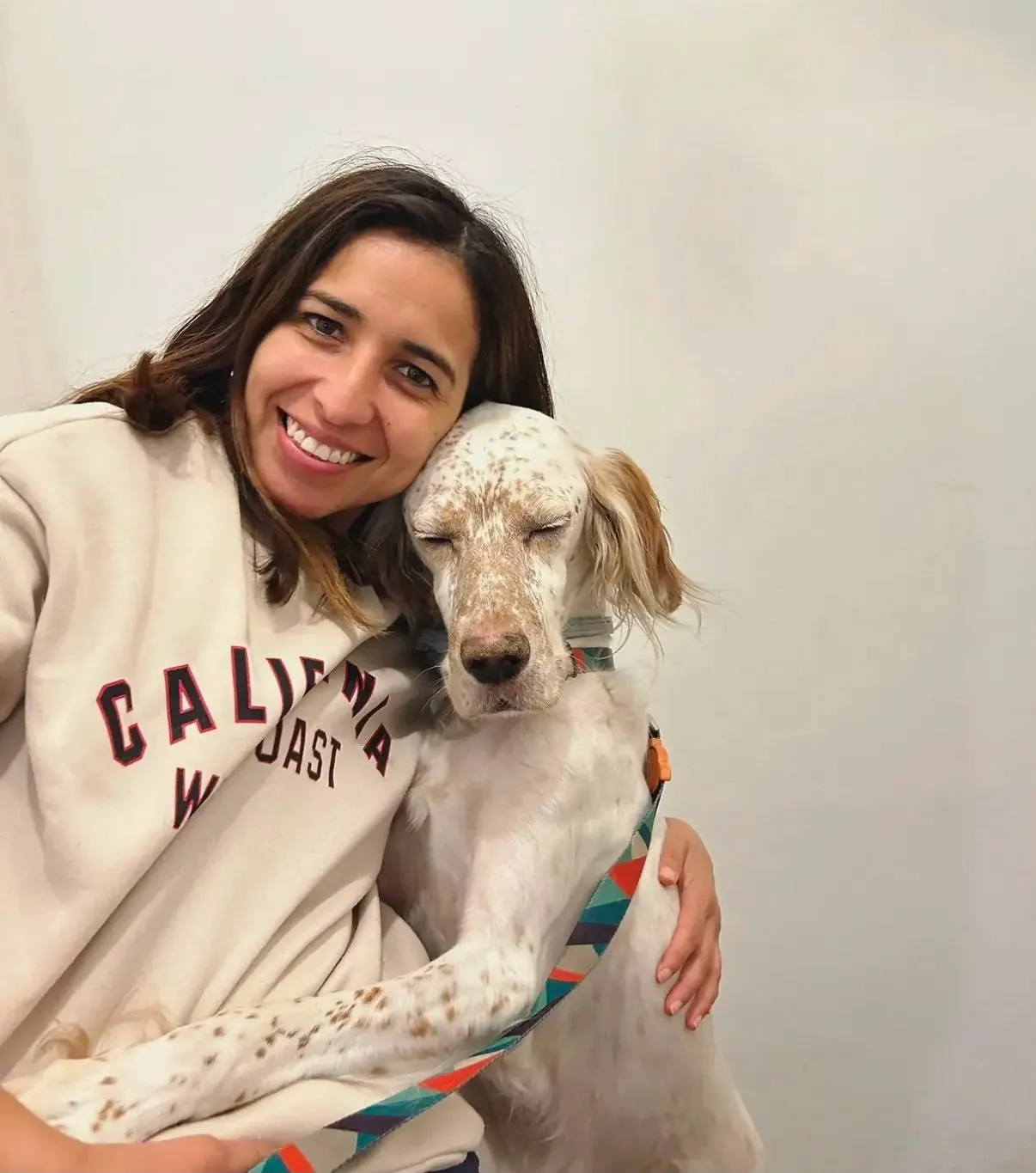 Mariana abrazando con ternura a un setter inglés que descansa tranquilo, símbolo de confianza y bienestar