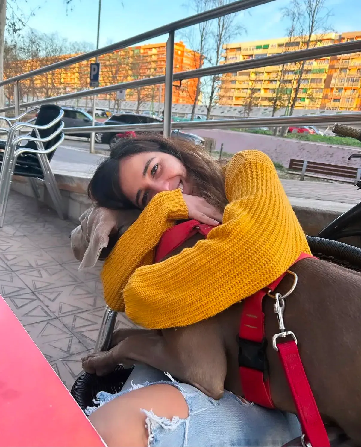 Mariana abrazando a un perro en la terraza de una cafetería dog-friendly de Barcelona